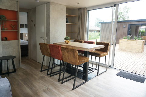 Essbereich mit sechs Stühlen und großem Tisch in der Family Lodge im Ferienpark De Boshoek, Niederlande.