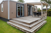 Udendørs foto af Family Lodge ved Holiday park De Boshoek i Holland med stor træterrasse.