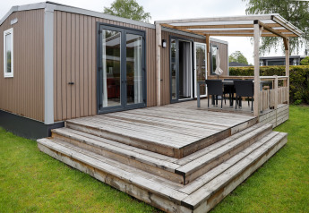 Außenaufnahme der Family Lodge im Holiday Park De Boshoek, Niederlande, mit Holzterrasse.