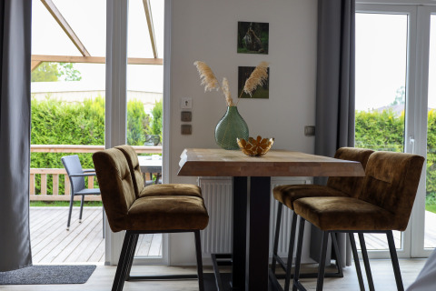 Essbereich mit vier braunen Stühlen und Tisch in der Family Lodge im Ferienpark De Boshoek, Niederlande.