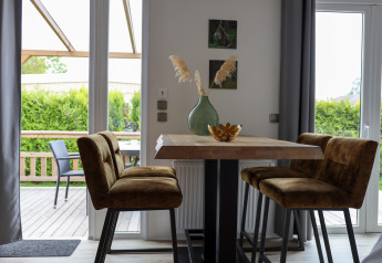 Eethoek met vier bruine stoelen en tafel in de Family Lodge bij Holiday park De Boshoek, Nederland.