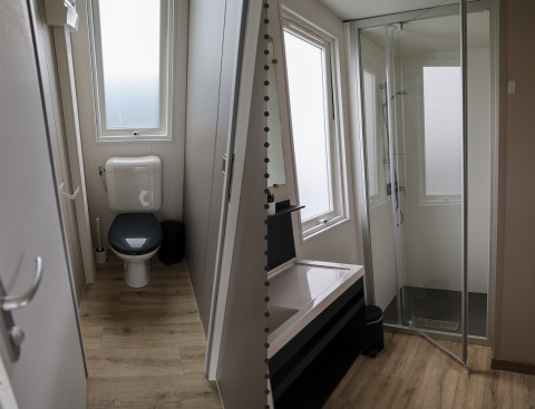 Et moderne familie-lodge badeværelse i Holiday park De Boshoek, Holland, med separat toilet og bruser.