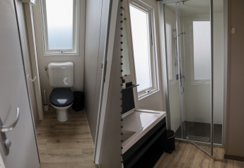 Modern family lodge badkamer in Holiday park De Boshoek, Nederland, met een apart toilet en aparte douche.