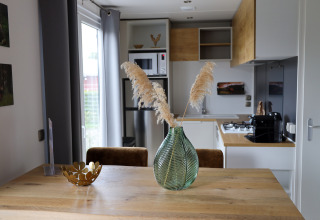Cucina moderna e zona pranzo nella Family Lodge al parco vacanze De Boshoek, Paesi Bassi, con decorazioni eleganti.