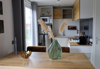 Cucina moderna e zona pranzo nella Family Lodge al parco vacanze De Boshoek, Paesi Bassi, con decorazioni eleganti.