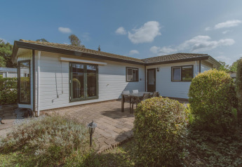 Buitenaanzicht van Wilbrink chalet in Holiday park De Boshoek, Nederland, met terras, tafel en groene struiken.