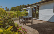 Buiten terras met zwarte tafel en stoelen bij Wilbrink chalet op Holiday park De Boshoek, Nederland, tuinzicht.