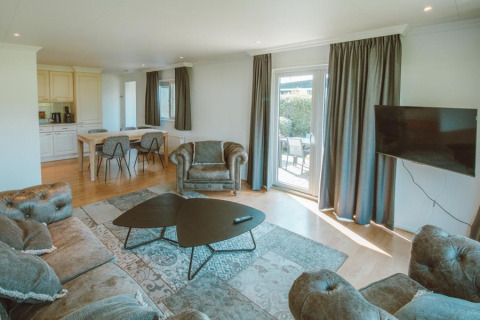 Woonkamer met banken en eettafel in Wilbrink chalet bij Holiday park De Boshoek, Nederland, lichte inrichting.