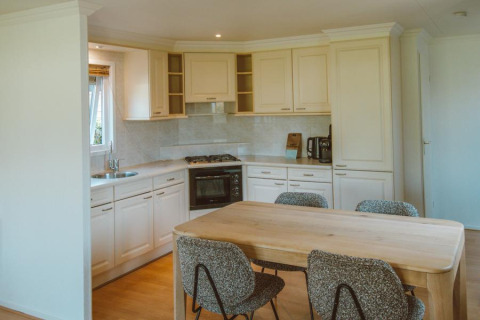 Moderne Küche und Essbereich im Wilbrink Chalet im Ferienpark De Boshoek, Niederlande, mit vier Stühlen.