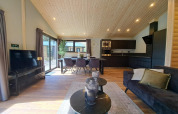 Moderne Lodge mit Holzdecke, Küche und Wohnzimmer in Hackfort Wood 6, De Utrechtse Heuvelrug, Niederlande.