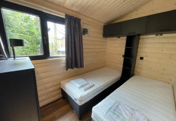 Gemütliches Schlafzimmer mit zwei Einzelbetten in der Hackfort Wood 6 Lodge, De Utrechtse Heuvelrug, Niederlande.