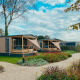 Due lodge Tiny Court al Holiday park De Boshoek nei Paesi Bassi, con terrazze in legno e giardini curati.