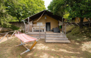 Tienda safari Villatent Wood en Camping Colleverde, Italia, con terraza de madera y hamaca al aire libre.