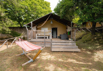 Safaritent Villatent Wood op Camping Colleverde in Italië met houten veranda en een gestreepte hangmat.