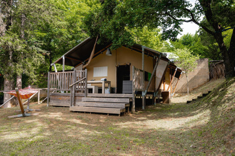 Tenda safari Villatent Wood al Camping Colleverde in Italia, immersa nel verde e circondata da alberi.