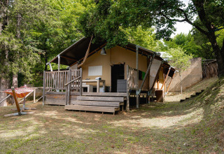 Tente safari Villatent Wood au Camping Colleverde en Italie, entourée d’arbres et de verdure, vue extérieure.