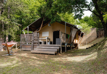 Safaritent Villatent Wood op Camping Colleverde in Italië, omringd door bomen, buitenaanzicht.