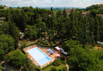 Vista aérea de una piscina rodeada de árboles verdes en Villatent Wood, Camping Colleverde, Italia.