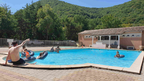 Piscina de parque vacacional en Camping Le Gallo Romain, Auvergne-Rhône-Alpes, Francia, con niños y adultos.