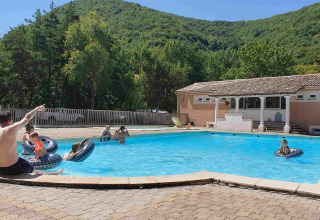 Feriepark pool i Camping Le Gallo Romain, Auvergne-Rhône-Alpes, Frankrig, med børn og voksne i solen.