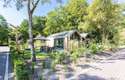 Casa pequeña y moderna Lodge Royal Eco rodeada de vegetación en Résidence Lage Vuursche, Países Bajos.