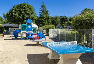Parque infantil al aire libre y mesa de ping-pong en Camping de Kerleyou, un parque vacacional en Bretaña, Francia.