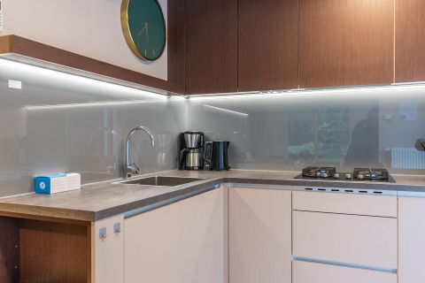 Cocina moderna en el lodge Enzian en Pressegger See, Austria, con fogones de gas, fregadero y cafetera.