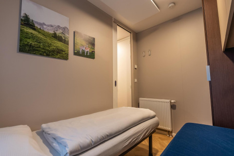 Gezellige kamer in de Enzian-lodge aan Pressegger See in Oostenrijk met natuurfoto’s aan de muur.