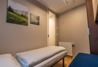 Gezellige kamer in de Enzian-lodge aan Pressegger See in Oostenrijk met natuurfoto’s aan de muur.