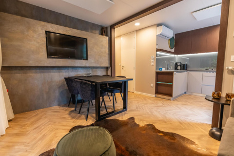 Moderne lodgewoning bij Enzian, Pressegger See, Oostenrijk, met eetruimte, tv en open keuken.