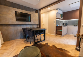 Moderne lodgewoning bij Enzian, Pressegger See, Oostenrijk, met eetruimte, tv en open keuken.