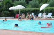 Ferieparkbesøgende nyder en solrig dag ved poolen på Camping Monti del Sole i Umbrien, Italien.