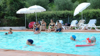 Vacanciers profitant d'une journée ensoleillée à la piscine du Camping Monti del Sole en Ombrie, Italie.