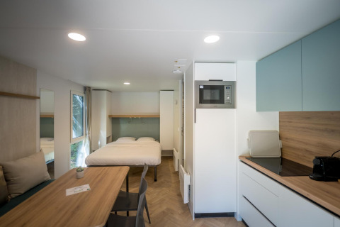 Moderne lodge på Urban-Gardens Ieper i Belgien med dobbeltseng, spisebord og fuldt udstyret køkken.