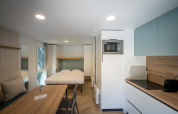 Lodge moderno en Urban-Gardens Ieper en Bélgica con cama doble, comedor y cocina totalmente equipada.