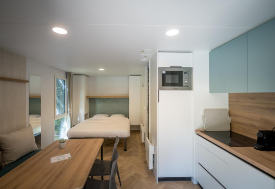 Moderne lodge på Urban-Gardens Ieper i Belgien med dobbeltseng, spisebord og fuldt udstyret køkken.