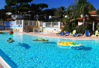 Piscina all'aperto con lettini e gonfiabili al Camping Les Lauriers Roses in Provenza-Alpi-Costa Azzurra.