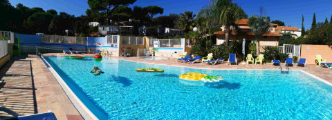 Piscina exterior con tumbonas y flotadores en Camping Les Lauriers Roses, Provenza-Alpes-Costa Azul, Francia.
