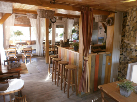 Gezellig café-interieur bij Camping Lou Passavous met houten meubels en rustiek in de Provence, Frankrijk.