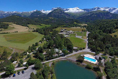 Vista aerea di Le Vernet in Provence-Alpes-Côte d’Azur, Francia, con montagne, campi e un lago.