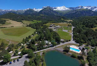 Vista aérea de Le Vernet en Provence-Alpes-Côte d’Azur, Francia, con montañas, campos y lago visible.