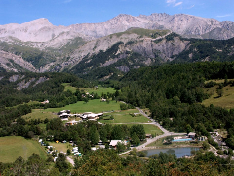 Vista panorámica de Le Vernet en Provence-Alpes-Côte d’Azur, rodeado de campos verdes y montañas escénicas.