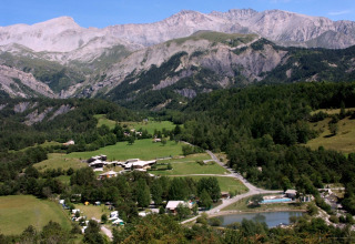 Panoramisch zicht op Le Vernet in Provence-Alpes-Côte d’Azur, omgeven door groene velden en bergen.