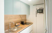 Lyst og moderne køkken i en lodge med træbordplade, vask, kogeplade og indbygget mikroovn.