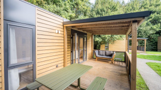 Terrasse extérieure au Lodgep - IEPER, Urban-Gardens Ieper, Belgique, avec table de pique-nique et canapé.