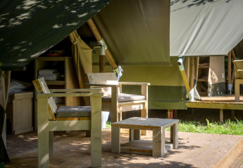 Holzmöbel auf einer Terrasse vor einem Safari-Glampingzelt in Urban-Gardens Ieper, Belgien.