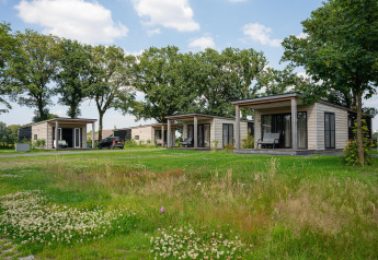 Panorama lodge met wellness en hot tub bij Vakantiepark Hölte, Nederland, omringd door natuur en bomen.