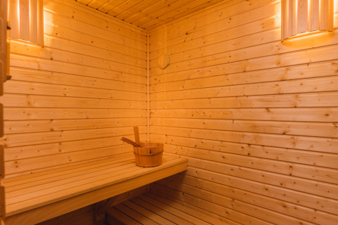 Interno di una sauna in legno con luce soffusa nella Panorama lodge, Vakantiepark Hölte, Paesi Bassi.