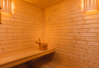 Innenraum einer Sauna aus Holz mit stimmungsvoller Beleuchtung in der Panorama Lodge, Vakantiepark Hölte, Niederlande.