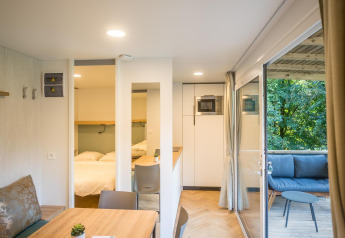 Foto interior de una moderna cabaña con comedor, dormitorio y terraza en Urban-Gardens Ieper, Bélgica.